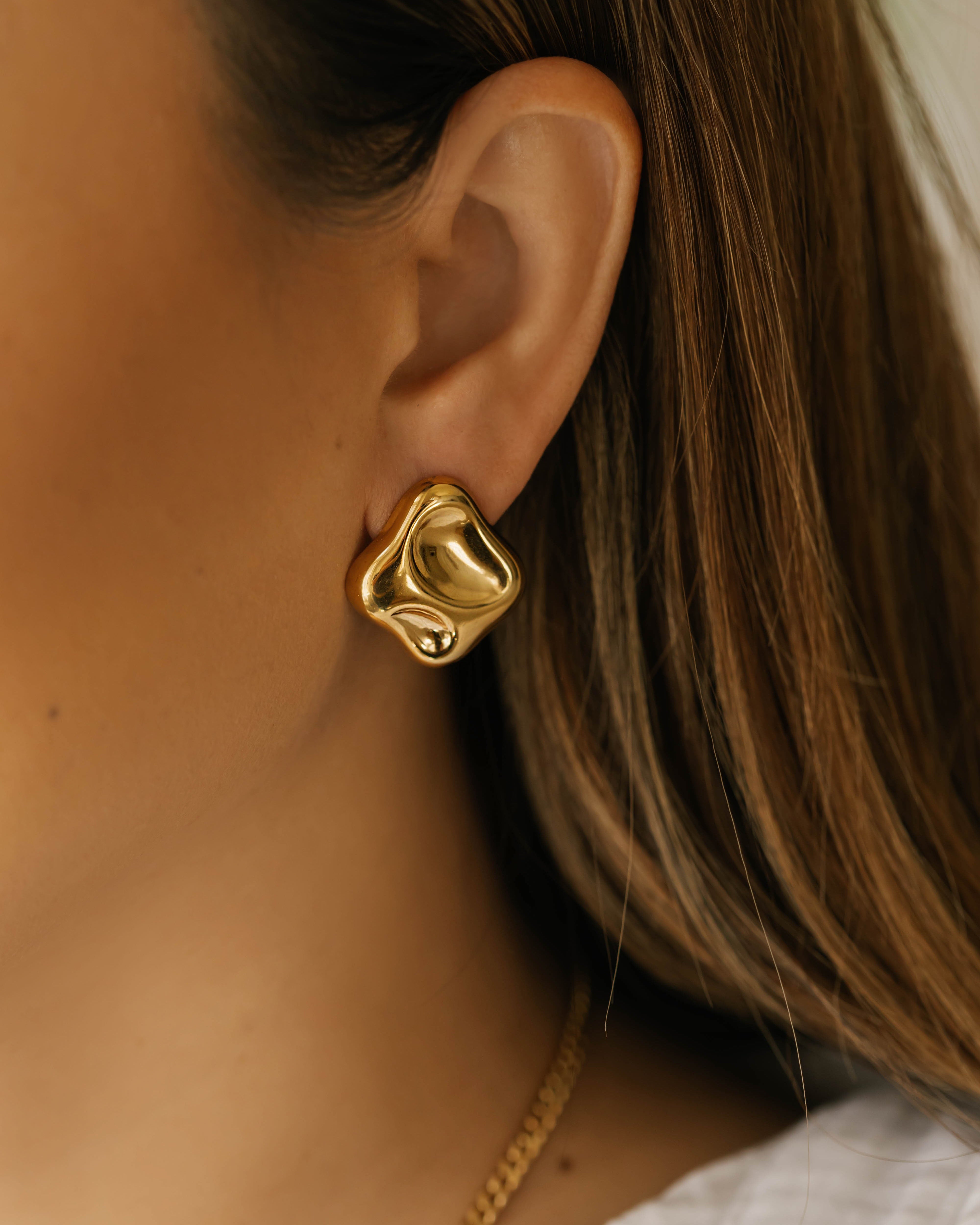 woman is wearing luxury gold organic shape earrings in canada