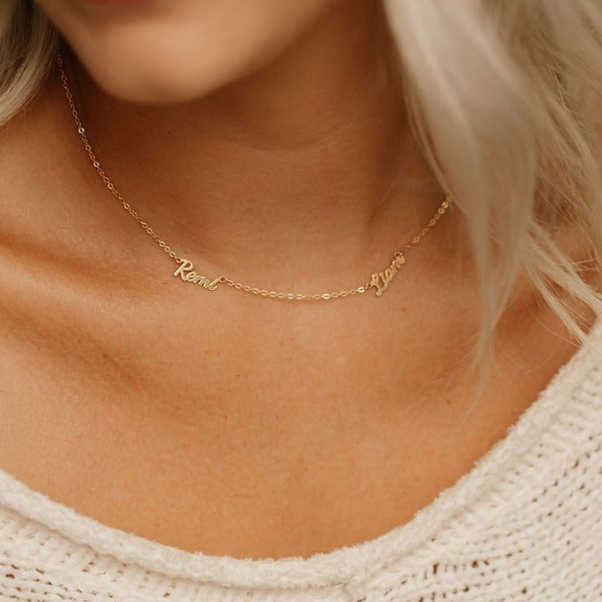 Mom wearing gold necklace with her kids names 