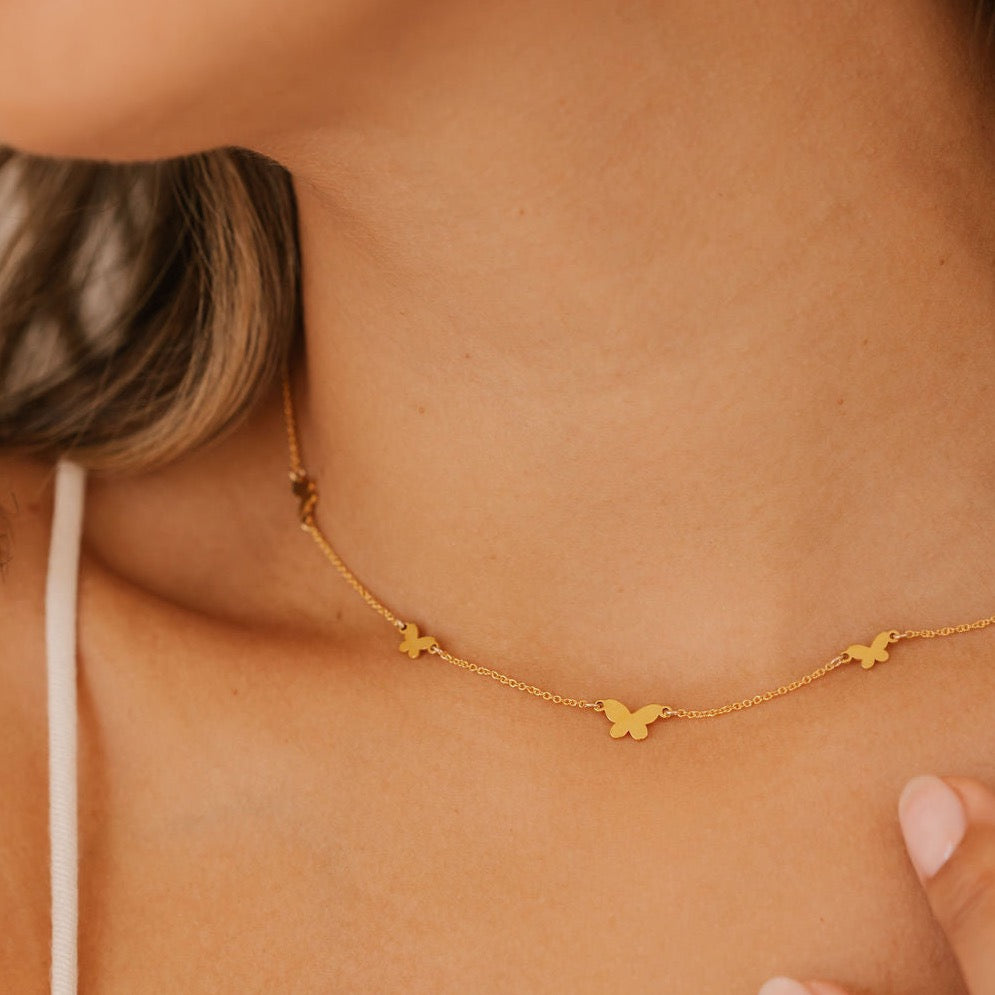 a woman is wearing gold vermeil butterfly choker made in Canada