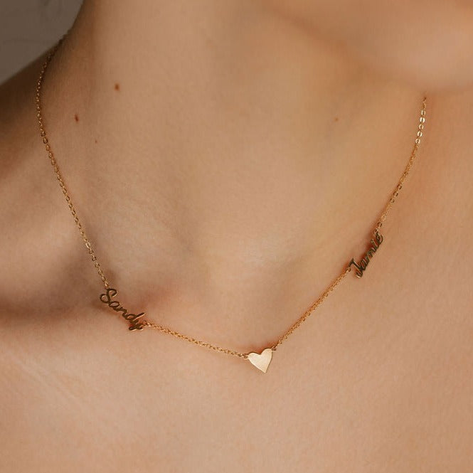 a woman is wearing a multiple name necklace with 2 names and heart pendant