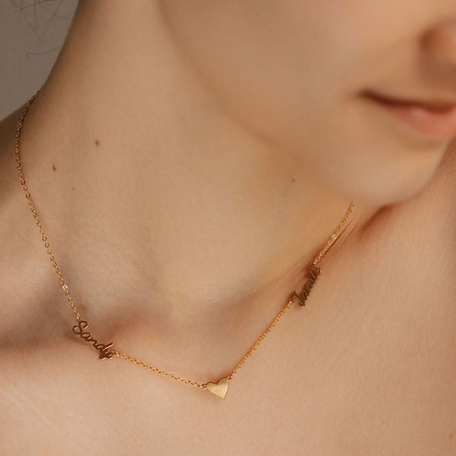 a woman is wearing multiple name heart necklace gold made in Canada