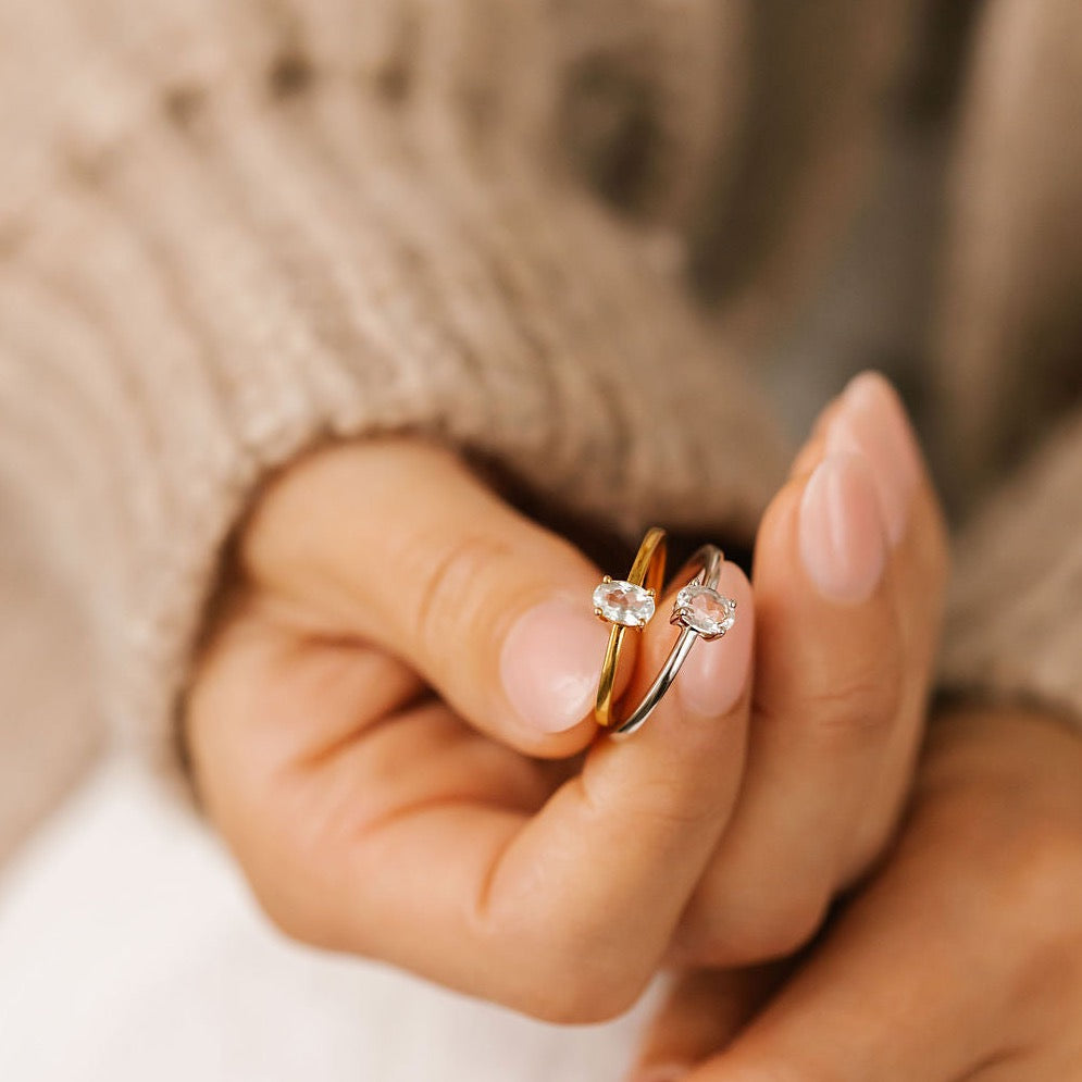 a woman is holding topaz silver and gold ring made in Canada