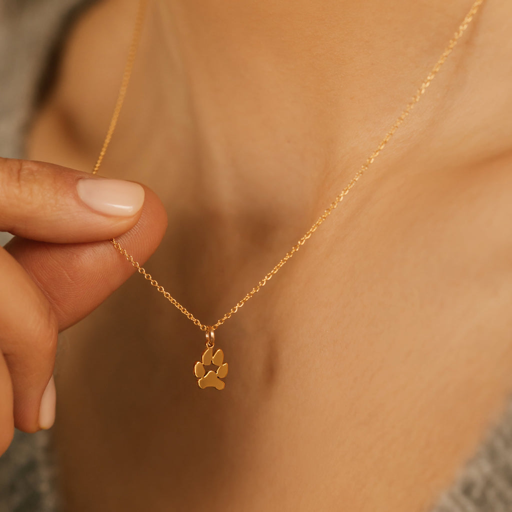 a gold paw print necklace made from actual paw prints
