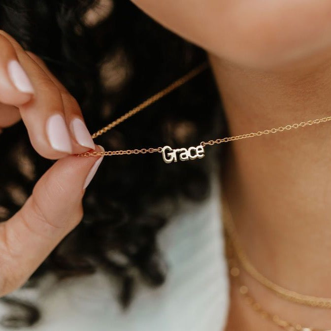 a lady holding the gold name plate pendant made in Canada
