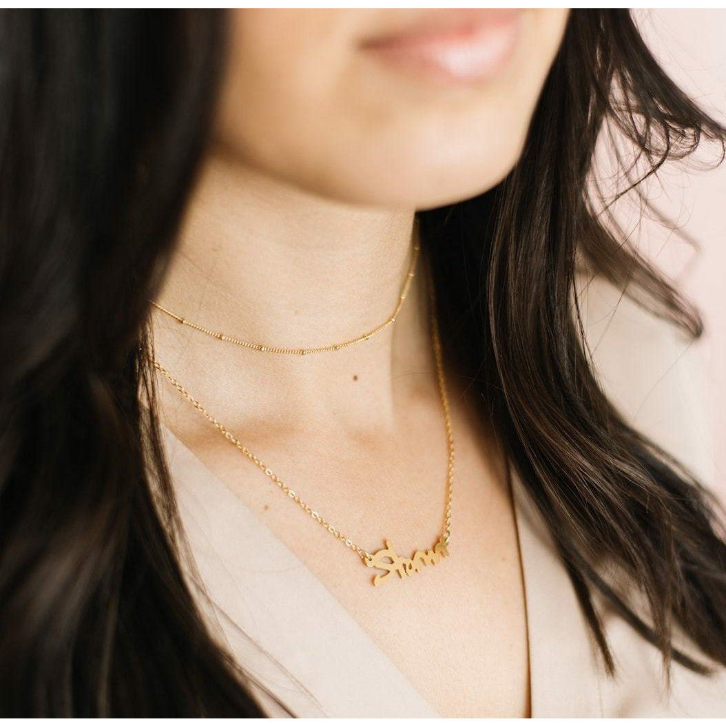 gold minimal choker necklace layered with a name necklace