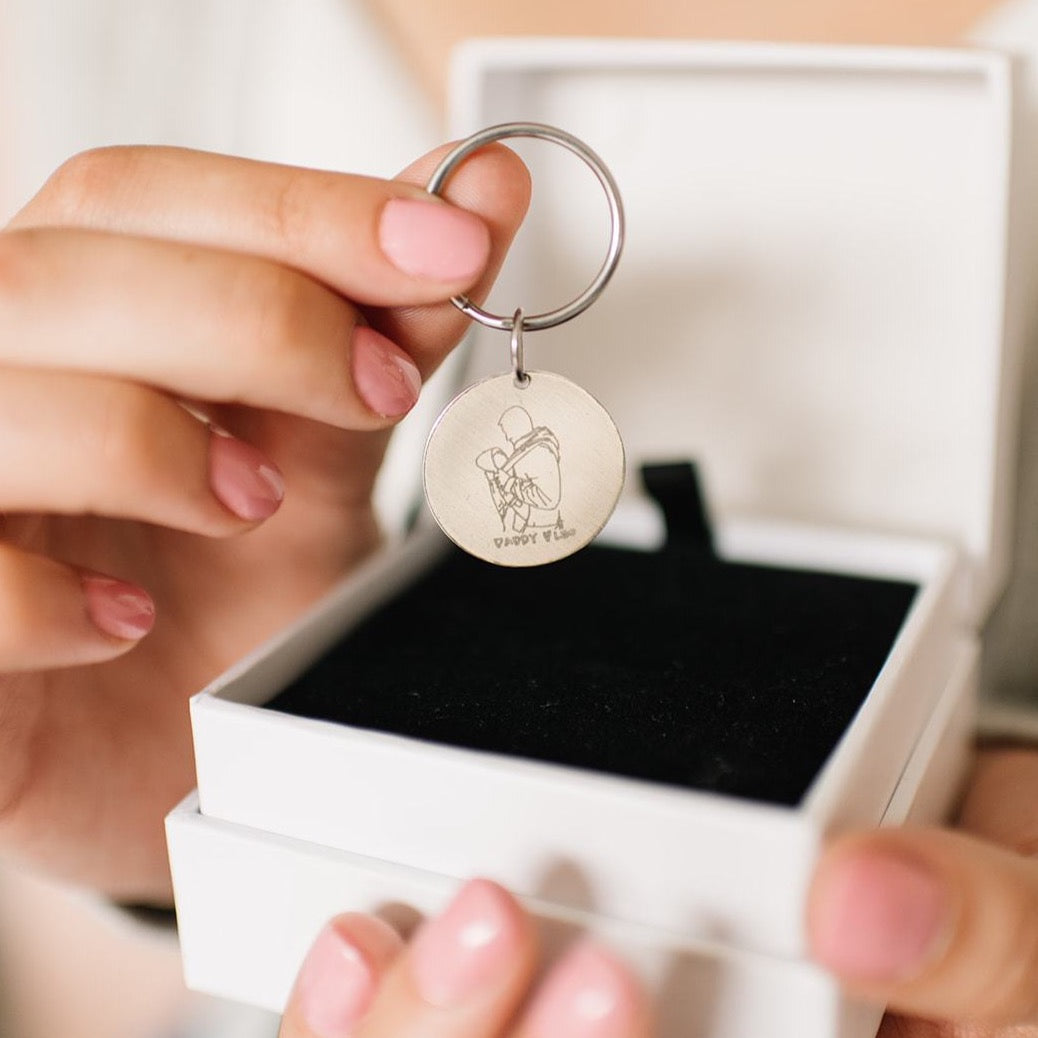 Woman pulling custom handmade sterling silver coin key chain out of box