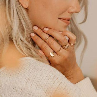 Model wearing minimalist rings layered and stacked